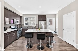 Contemporary kitchen featuring wood-finish flooring and recessed lighting - 