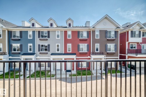 Row of contemporary townhomes featuring varied siding colors and gable dormers - #10 2803 James Mowatt Trail Sw, Edmonton, AB - Outdoor With Facade