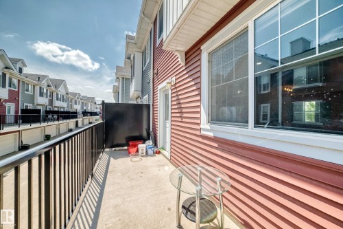 Exterior balcony featuring a concrete surface, black metal railings, and a privacy wall - #10 2803 James Mowatt Trail Sw, Edmonton, AB - Outdoor