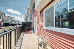Exterior balcony featuring a concrete surface, black metal railings, and a privacy wall - 