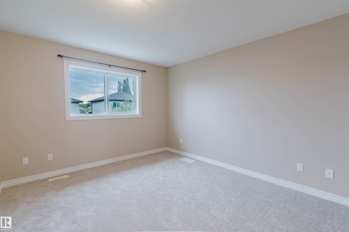 Carpeted room featuring a single window with white trim, neutral wall paint, and white baseboards - 1919 Hammond Place, Edmonton, AB - Indoor Photo Showing Other Room