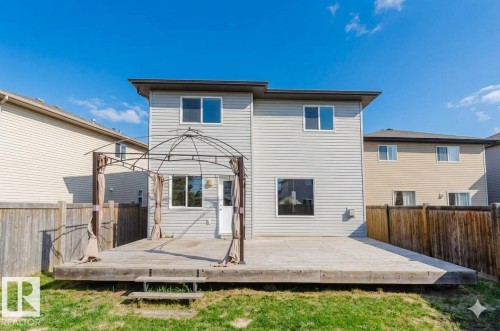 Backyard featuring an expansive wood deck with a gazebo frame, a verdant lawn, and privacy fencing - 1919 Hammond Place, Edmonton, AB - Outdoor With Exterior