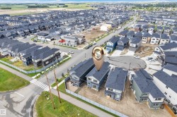 Aerial perspective showcasing a developing residential neighborhood with numerous detached homes featuring dark shingle roofs and varied exterior finishes - 