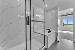 Spacious bathroom featuring large format marble-look wall tiles, a built-in tub with matte black fixtures, a walk-in shower with clear glass enclosure and black trim, and dark tile flooring - 
