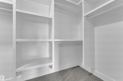 Custom closet system featuring white shelving and hanging rods - 