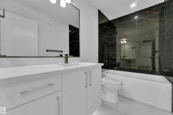 Modern bathroom featuring a single vanity with a white countertop and integrated sink - 