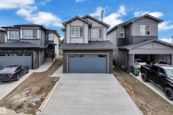 Modern two-story home featuring a grey and white exterior with stone accents - 