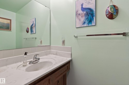 Bathroom vanity featuring an integrated sink, polished chrome faucet, and a stone-finish countertop - 10 Abbey Crescent, St. Albert, AB - Indoor Photo Showing Bathroom