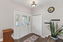 Entryway featuring a white door with decorative glass inserts and two sidelights - 