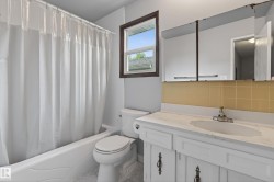 Bathroom featuring a white vanity with an integrated sink, chrome faucet, and a wall-mounted mirrored cabinet - 