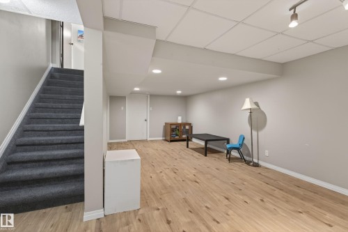Finished lower level featuring recessed lighting, wood-finish flooring, a neutral color palette, and a paneled ceiling - 10 Abbey Crescent, St. Albert, AB - Indoor