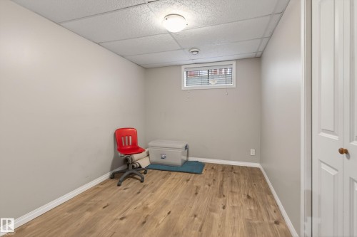 Versatile room featuring wood-finish flooring, light neutral wall paint, and a drop ceiling with recessed lighting - 10 Abbey Crescent, St. Albert, AB - Indoor