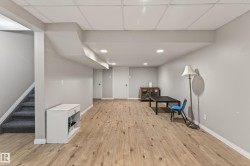 Finished lower level featuring wood-finish flooring, recessed lighting, and a drop ceiling - 