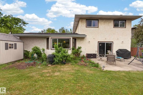 Rear exterior featuring stucco siding, multiple windows, and a sliding patio door - 10 Abbey Crescent, St. Albert, AB - Outdoor