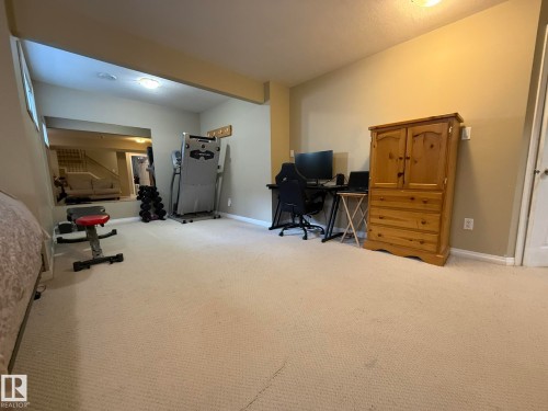 Carpeted room with a recessed area featuring a window, overhead lighting, and light-toned walls - 1820 Robertson Crescent Sw, Edmonton, AB - Indoor