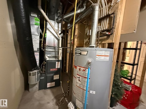 Goodman furnace with associated ductwork, water heater, and PEX plumbing manifold - 1820 Robertson Crescent Sw, Edmonton, AB - Indoor Photo Showing Basement