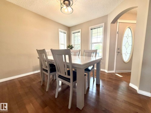 Warm wood-finish flooring complements the neutral wall tones - 1820 Robertson Crescent Sw, Edmonton, AB - Indoor Photo Showing Dining Room