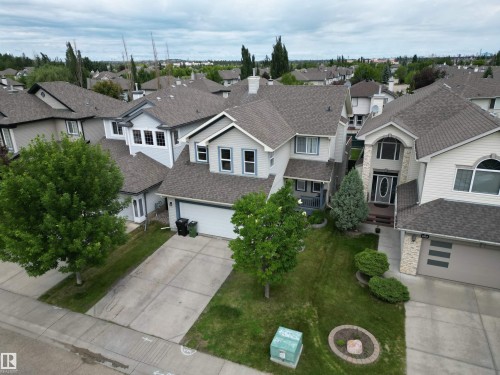 Two-story residence featuring light-toned siding, a dark shingle roof, and an attached two-car garage - 1820 Robertson Crescent Sw, Edmonton, AB - Outdoor With Facade