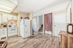 Kitchen space featuring white cabinetry, a white electric range, and a white refrigerator - 