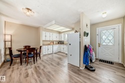 Open-concept kitchen and dining area featuring wood-finish flooring - 
