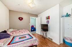 Room featuring wood-finish flooring, white walls, and a textured ceiling - 
