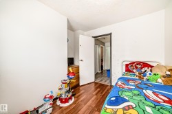 Interior room featuring wood-finish flooring and white painted walls - 