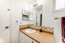 Bathroom vanity featuring a single basin, laminate countertop, and decorative tile backsplash - 