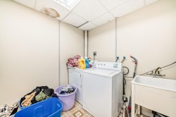 Utility room featuring a drop ceiling with recessed lighting, light-toned walls, and patterned flooring - 