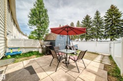 Patio area featuring concrete pavers, a privacy fence, a mature tree, and a storage shed - 