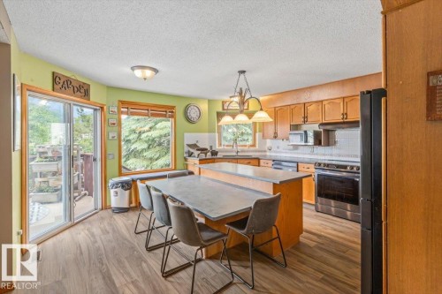 Kitchen featuring wood-finish flooring, natural wood cabinetry, and stainless steel appliances - 16 Harrold Place, St. Albert, AB - Indoor