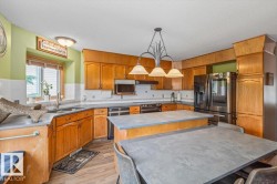 Kitchen featuring wood cabinetry, stainless steel appliances, and wood-finish flooring - 