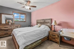 Room featuring a ceiling fan with integrated lighting, a window with horizontal blinds and a wood-finish frame, and two-tone painted walls - 
