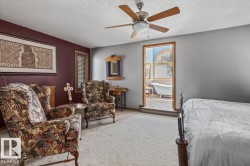 Spacious room featuring carpeting, a ceiling fan, and direct access to a bathroom with a visible clawfoot tub and arched window - 