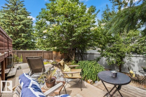 Private backyard patio featuring a wood privacy fence and mature trees - 16 Harrold Place, St. Albert, AB - Outdoor With Deck Patio Veranda