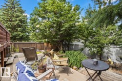 Private backyard patio featuring a wood privacy fence and mature trees - 