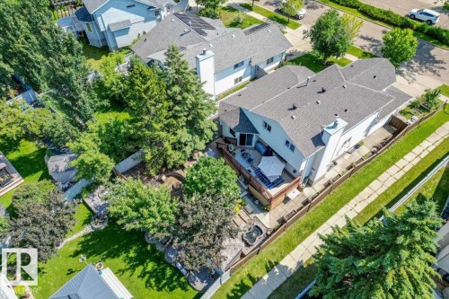 Aerial perspective highlighting the property's exterior, including a multi-level deck, fenced yard, and mature trees - 16 Harrold Place, St. Albert, AB - Outdoor With View