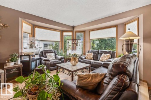 Bay window feature with natural wood-finish trim and integrated blinds - 16 Harrold Place, St. Albert, AB - Indoor Photo Showing Living Room