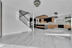 Spacious open concept interior featuring large format marble-look tile flooring - 