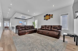Spacious living area featuring light wood-finish flooring and ample natural light from multiple windows - 