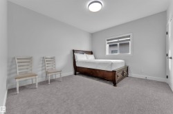 Carpeted bedroom featuring a single window with blinds, a flush-mount ceiling light fixture, and white baseboards - 