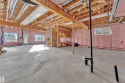 Unfinished basement with concrete flooring and exposed ceiling joists - 