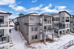 Modern stucco exterior with multiple balconies featuring glass railings and support columns - 