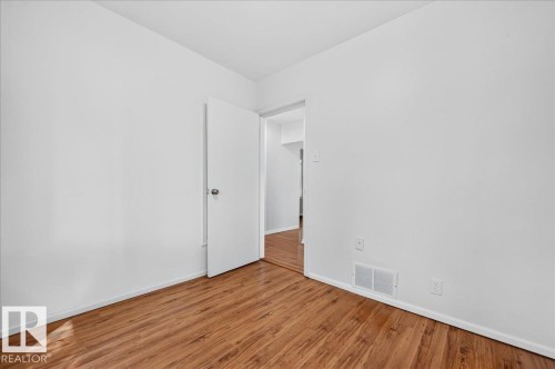 Room featuring wood-finish flooring, white walls, and white trim - 12134 42 Street Nw, Edmonton, AB - Indoor Photo Showing Other Room