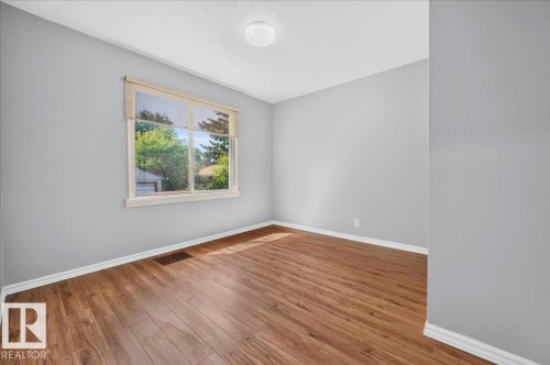 Light gray walls with white trim and wood-finish flooring - 12134 42 Street Nw, Edmonton, AB - Indoor Photo Showing Other Room