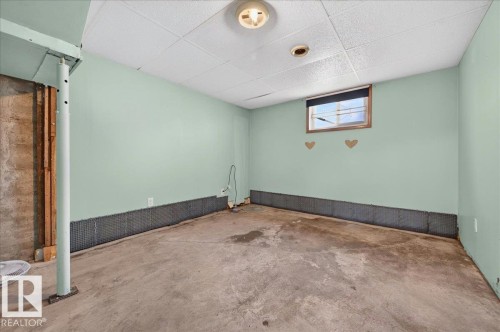 Room featuring a drop ceiling with recessed lighting, painted walls, a window, and exposed concrete flooring - 12134 42 Street Nw, Edmonton, AB - Indoor Photo Showing Other Room
