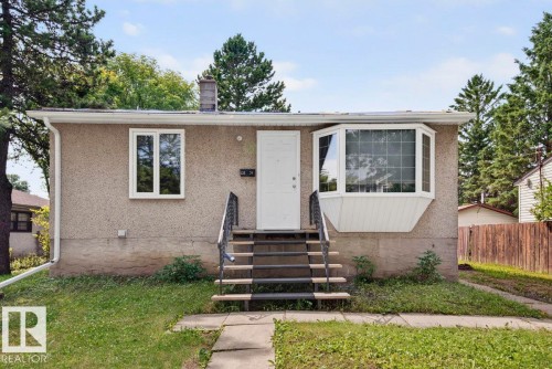Exterior featuring a prominent bay window, stucco siding, and a concrete walkway leading to the front entry - 12134 42 Street Nw, Edmonton, AB - Outdoor