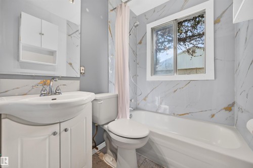 Bathroom featuring a white vanity with integrated sink, white cabinetry, and polished chrome faucet - 12134 42 Street Nw, Edmonton, AB - Indoor Photo Showing Bathroom