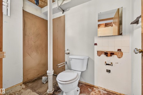White commode and wall-mounted mirror - 12134 42 Street Nw, Edmonton, AB - Indoor Photo Showing Bathroom