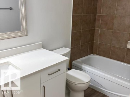 Bathroom featuring a white vanity with an integrated sink and light-colored countertop - #103 10023 164St St Nw, Edmonton, AB - Indoor Photo Showing Bathroom