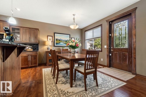 Virtually staging creates a warm, inviting dining space that helps potential buyers envision gathering here for meals. The styling balances the room's proportions and draws attention to the lovely architectural details like the hardwood floors and - 25 Hilltop Ridge, Fort Saskatchewan, AB - Indoor Photo Showing Dining Room